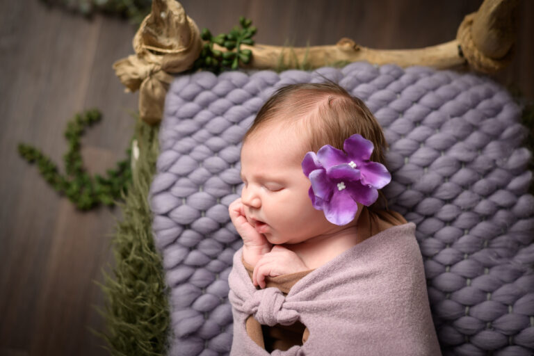 photo bébé avec fleurs dans un lit en bois studio photographe le grau du roi gard